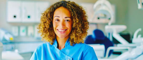 young smiling woman in scrubs in a medical office